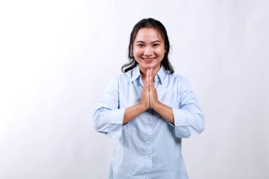 Gülen ve gülümseyen mutlu Asyalı bir kızın görüntüsü. Teşekkür ediyor, namaste jesti, smth için minnettar, beyaz arka planda duruyor.