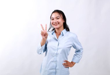 Gülümseyen mutlu Asyalı kız tavsiye veriyor, iki parmağını gösteriyor kuralları açıklarken, işaret ediyor, beyaz arka planda duruyor