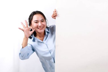 Mutlu gülümseyen genç bir kadın beyaz arkaplan üzerinde izole bir şekilde el hareketi yaparken slogan ya da metin için boş tabela ya da telif alanı gösterir.