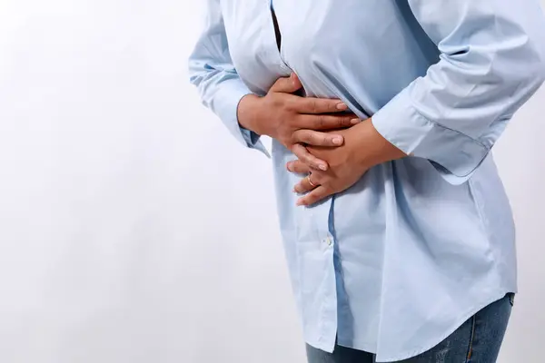 stock image Close up photo of woman's hand holding stomach. Stomach ache concept