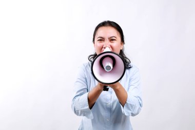 Sosyal adaletsizlik. Kızgın genç Asyalı kadın yüksek sesle mesaj vermek için megafon kullanıyor.