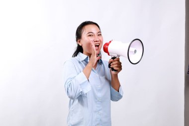 Asyalı kadın iki eliyle megafon tutarken çığlık atıyor.