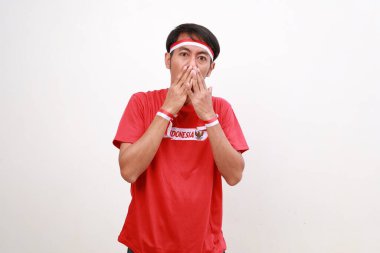 Endonezya 'nın bağımsızlık gününü kutlayan kırmızı beyaz kurdeleli Asyalı çocuk ağzını kapatırken şok oldu.