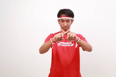 Endonezya 'nın bağımsızlık gününü kutladığı için kırmızı beyaz kurdeleli Asyalı çocuk parmaklarıyla hareketi reddederken ayakta duruyor.