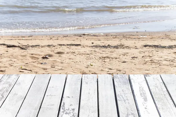 Kirli bir deniz kenarında eski ahşap zemin