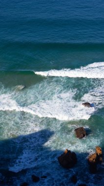 Dalgalar Praia da Ursa, Portekiz 'de Kıyı Kayalıklarına Çarpıyor. Derin Mavi Atlantik Okyanusu ve Güneş Işığı Gölgeleri
