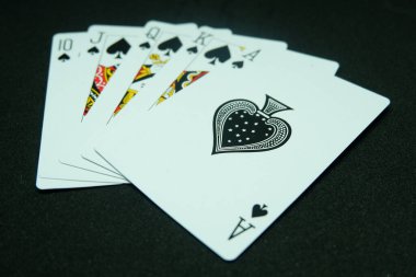 Royal Floş of Spade (Hepsi aynı takım, A-K-Q-J-T dizisi) siyah arkaplan 