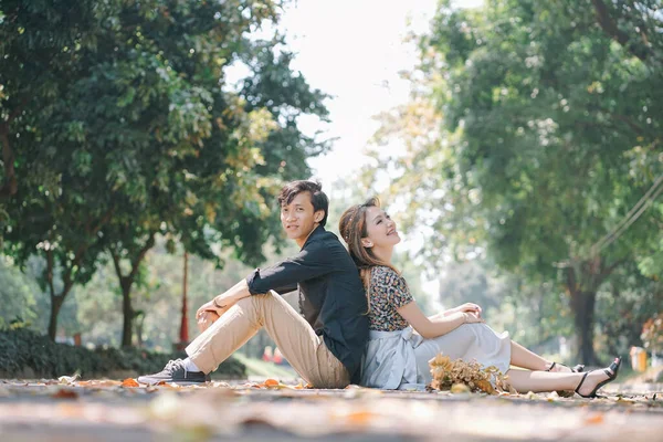 Пара Сидящая Опираясь Друг Друга Наслаждаясь Опавшими Листьями Парке — стоковое фото