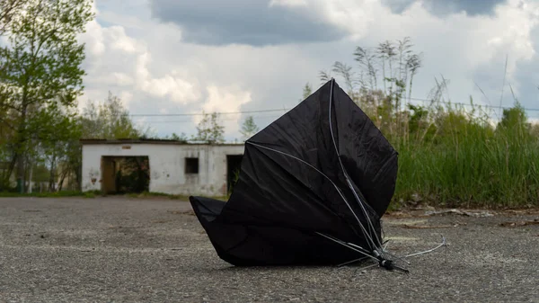 A broken umbrella lies on the asphalt after being destroyed by a strong wind. Poland
