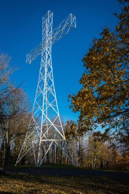 Küçük bir dağın tepesinde çelik bir haç. Din