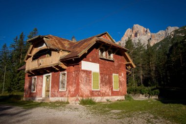 Güzel kırmızı, terk edilmiş bina Dolomitlerin içinde duruyor. Dolomitler, İtalya