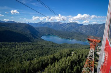 Görüntü, dağ teleferiği penceresinden. Seilbahn Zugspitze, Eibsee Gölü 'nden Zugspitze' nin tepesine uzanan bir hava tramvayıdır. Yukarıdan Alp Dağları 'nın zirvelerine bak. Bavyera Alplerinde Zugspitze Massif