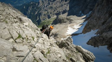 Alplerdeki Ferrata patikasında ekipmanlı bir turist. Zugspitze Massif, Bavyera Alpleri