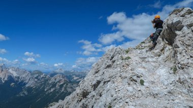 Turist, Dolomitler 'deki dağ yolundan güzel manzaraların fotoğrafını çeker. Dolomitler, İtalya