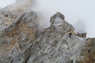 Alplerdeki Ferrata patikasında ekipmanlı bir turist. Dolomitler, İtalya