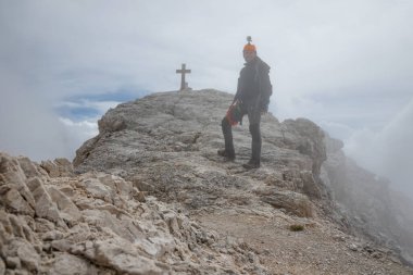 İtalyan Dolomitlerindeki Cima di Mezzo dağının zirvesinde sisli bir turist.