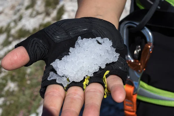 Tourist holding ice balls in the middle of summer on the trail in the Italian Dolomites