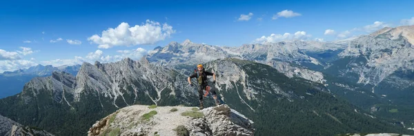 A tourist stands and poses against the backdrop of a mountain panorama in the Dolomites. Dolomites, Italy