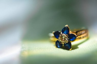 Güzel bir alyans yakın plan, tipik olarak sol yüzük parmağına takılan bir yüzük, genellikle metalden yapılır, geleneksel olarak altından ya da başka değerli bir metalden. Takan kişinin evli olduğunu gösterir.