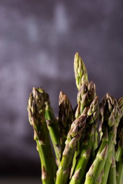 Koyu arka plan üzerinde taze yeşil kuşkonmaz