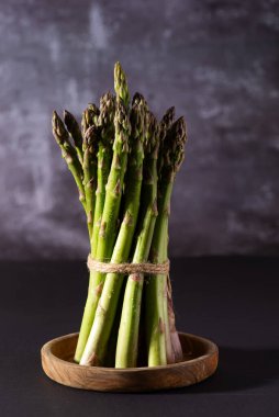 Koyu arkaplanda taze yeşil kuşkonmaz