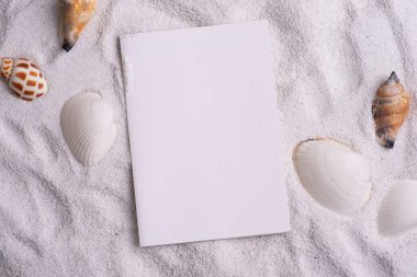 Yaz düz plaj kumu tasarımı ve boş bir kağıt kartıyla yatıyordu. Konseptler: doğa tatilleri, yaz seyahatleri.