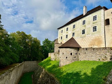 A photograph captures a close-up of a medieval Czech castle at sunset on a summer evening. clipart