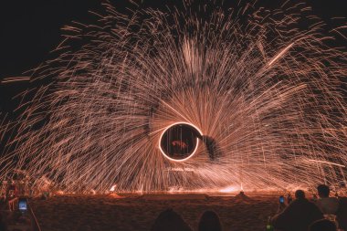 Yaz tatili konsepti, Koh Samui, Tayland 'da gece partisinde deniz üzerinde su yansıtan çelik yün ören adam.