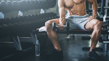 Spor salonunda spor yapan ve halter kaldıran Asyalı spor adamı, sağlıklı yaşam tarzı konsepti