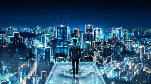 ビジネス技術コンセプト 将来のネットワーク都市の背景と夜の未来的なインターフェイスグラフィックを歩くプロフェッショナルビジネスマン ロイヤリティフリーのストック写真