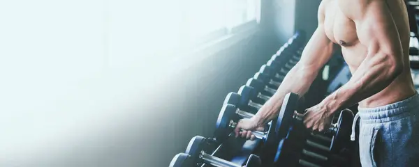 フィットネスアジアの男性は運動し スポーツジムでダンベルウェイトを持ち上げ 健康的なライフスタイルのコンセプト ロイヤリティフリーのストック画像