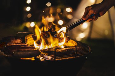 Family making barbecue in dinner party camping at night