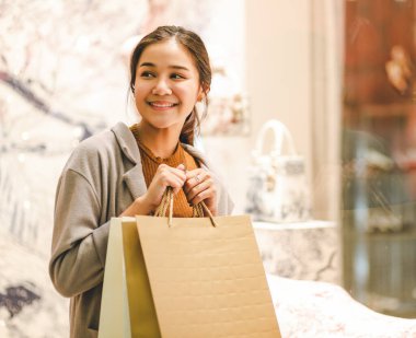 Yaşam tarzı alışveriş konsepti, alışveriş merkezinde kağıt torba ve ceket ile Genç mutlu asyalı kadın, vintage tarzı