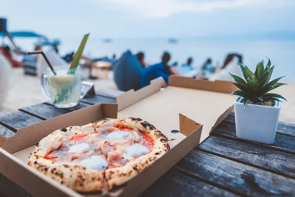 新鮮な自家製イタリアのピザマルゲリータ パルマハムと紙箱のモッツァレラチーズ 夕方にビーチクラブパーティーに行くには サムイ フードデリバリーコンセプト ストック画像