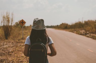 Tayland 'da seyahat çantalı gezgin Asyalı bir kadının kır yolunda yürüdüğünü gördüm.