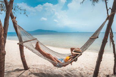 Yaz tatili konsepti, şapkalı mutlu Asyalı kadın Koh Rap, Samui, Surat Thani, Tayland 'da hamakta dinleniyor.