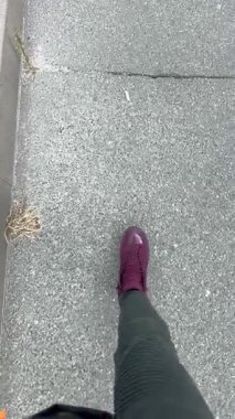 Mor Spor Ayakkabı ve Yeşil Pantolon Giyen, Asfalt Kaldırımda Yürüyen