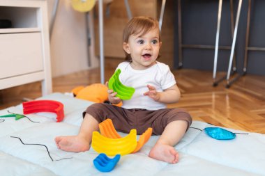 Evde plastik oyuncaklarla oynayan sevimli bir çocuk, sığ bir tarla derinliği
