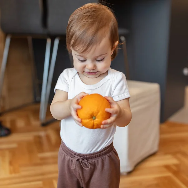 1歳の子供がオレンジで遊んで フィールドの浅い深さ — ストック写真