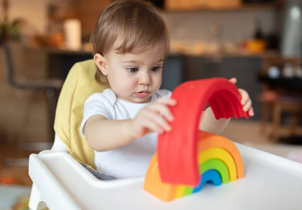 Adorable one year old child playing with plastic toys at home, shallow depth of field
