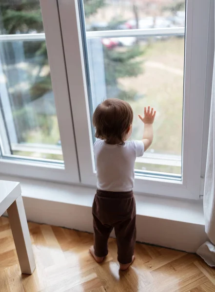 stock image Portrait of adorable one year old child looking trough the window, shallow depth of field