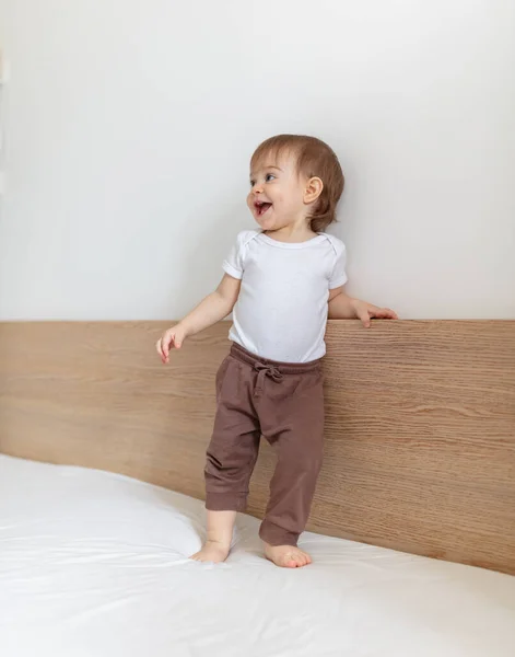 可爱的12个月大的孩子笑着躺在床上 图库图片