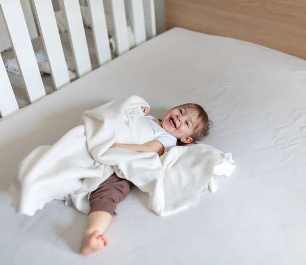 Liebenswertes Monate Altes Kind Spielt Mit Decke Bett lizenzfreie Stockbilder