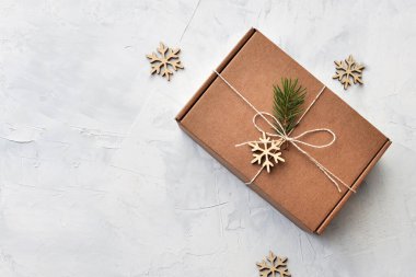 Masanın üzerinde Noel süsü olan bir hediye kutusu.