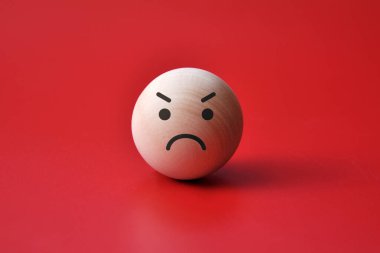 Kızgın yüzlü tahta bir top. Öfkenin sembolü