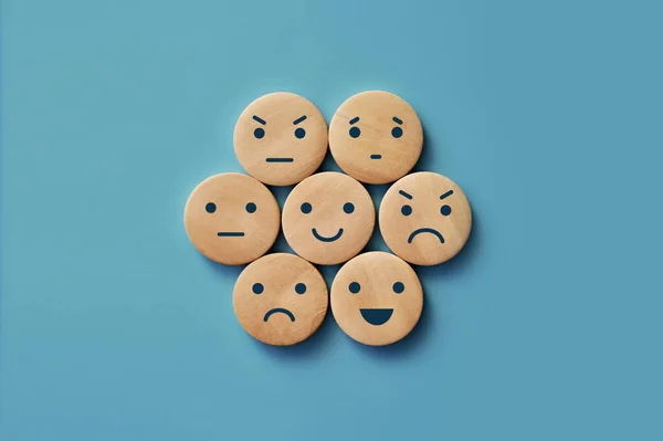 A variety of human emotions: joy, serenity, anger, sadness, delight, surprise on wooden circles