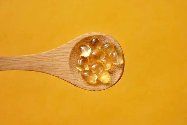 Capsules with vitamins on a spoon. A complex of vitamins for health