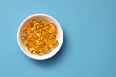 Mavi zemin üzerinde bir tabakta sarı kapsüller