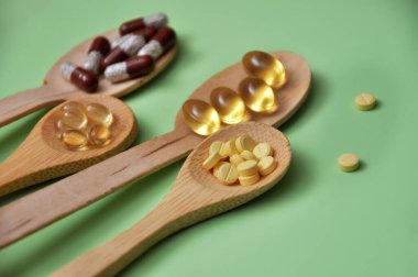 Tabletler, kapsüller, diyet takviyeleri, tahta kaşıklarda vitaminler. Tıbbi geçmiş