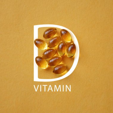 Sarı zemin üzerinde kapsüller halinde D vitamini